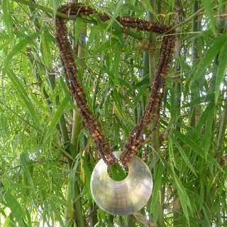   beach style wood necklace with a huge round shell that complements